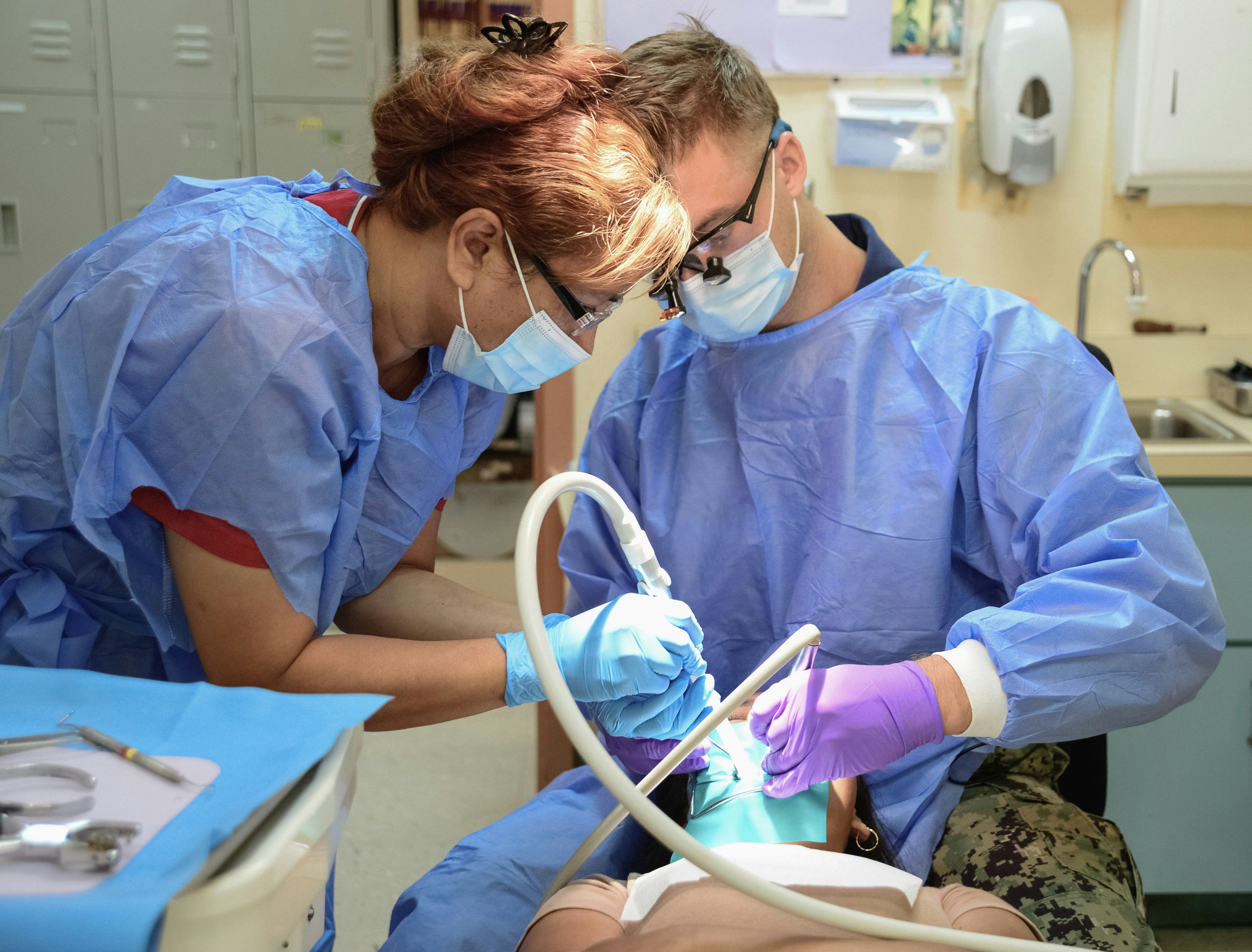 Dentist in a UK surgery reviewing NHS contract paperwork, reflecting pressures behind the NHS dental exodus