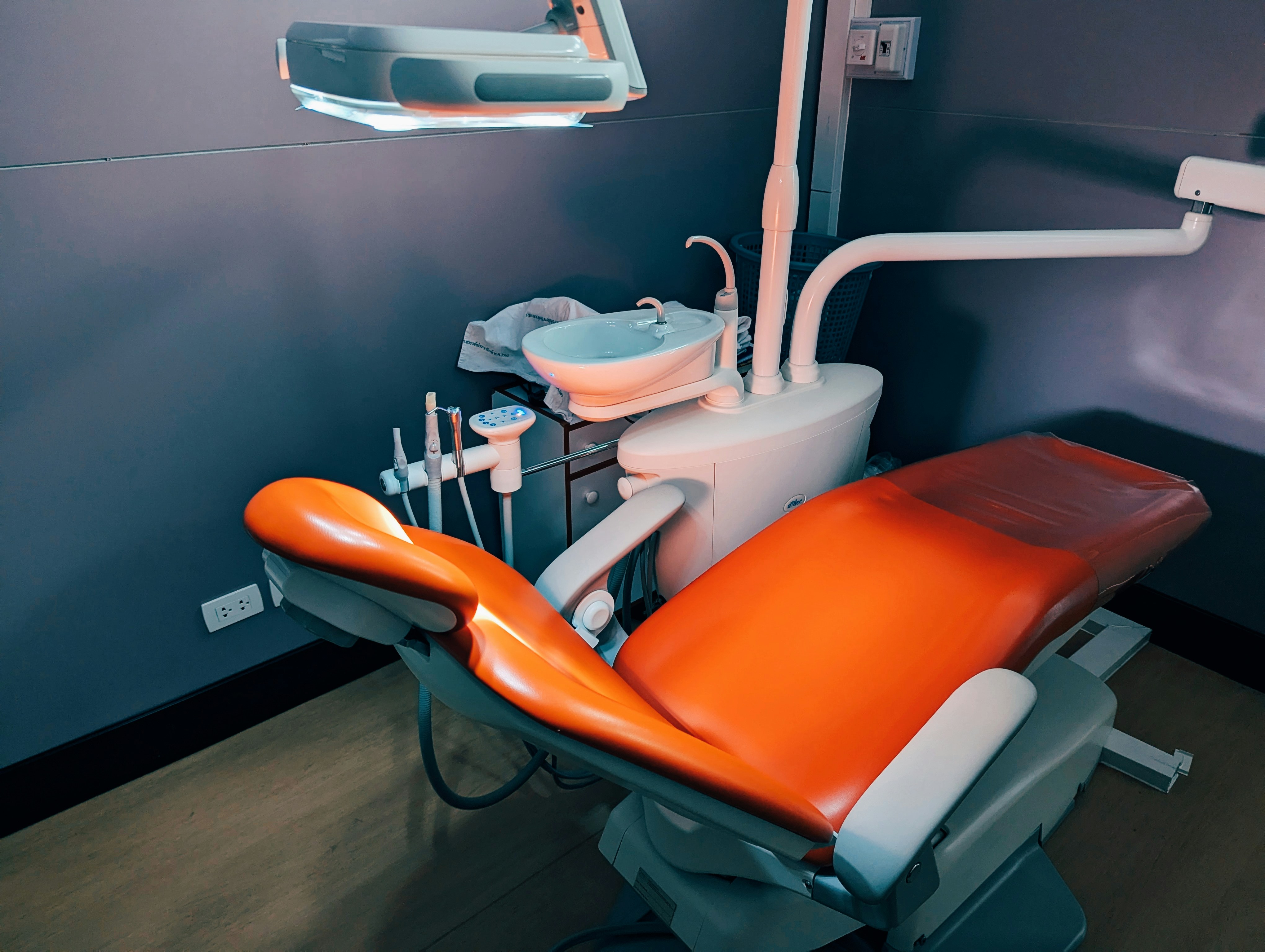 Dental practice reception area with patient booking system and treatment price list displayed prominently on wall